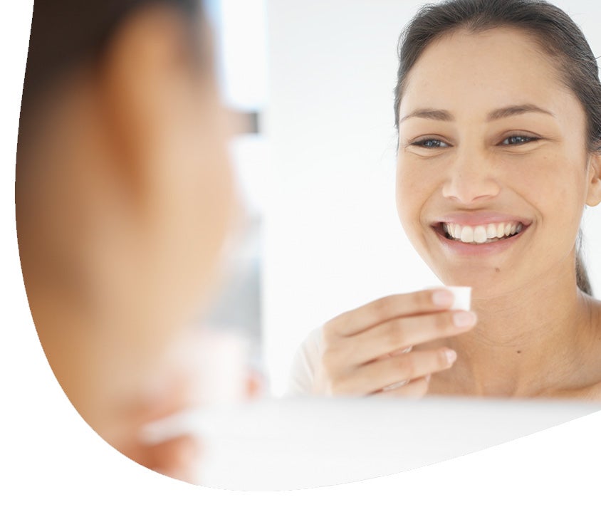 A woman using mouthwash to combat gum disease